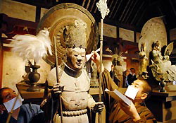 Священники очищают от паутины статую Будды в Наре