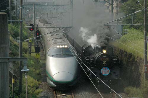 A Yamagata Shinkansen line Tsubasa train runs next to a steam locomotive near Kajo Park, Yamagata