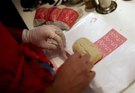Работник одного из парижских ресторанов готовит сэндвичи стоимостью 1€. 23-е апреля 2009 г.