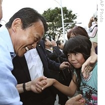 Премьер-министр Таро Асо (слева) пожимает детям руки в рамках предвыборной кампании в Кумагае. 25-е августа 2009 г.