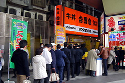 Люди стоят в очереди в ресторан Ёсиноя (Yoshinoya) в районе Токио Тиёда (Chiyoda) после того, как ресторан снизил цену на свое дежурное блюдо гюдон (рис с говядиной по-японски) до 270 иен