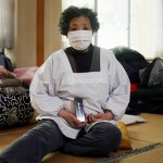74-летняя женщина держит деревянную табличку с посмертным именем одного из предков: «Мне говорили в случае бедствия спасать табличку, так что я рада, что смогла найти её». Рикудзэнтаката, префектура Иватэ. 12-е апреля 2011 г.