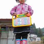 4-летняя девочка с подаренной игрушкой. Её семья остаётся в эвакуационном центре в Оцути, префектура Иватэ. 7-е апреля 2011 г.