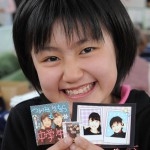 12-летняя девочка держит наклейки со своими фотографиями и фотографиями подруг. По её словам, двум из четырёх её одноклассников придётся перейти в другую школу в связи с катастрофой. Мияко, префектура Иватэ. 9-е апреля 2011 г.