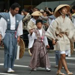 Судя по розочке на поясе, этот мальчик был представителем общины в начале парада, когда представители общин подтверждают свою очередность в параде у мэра Киото